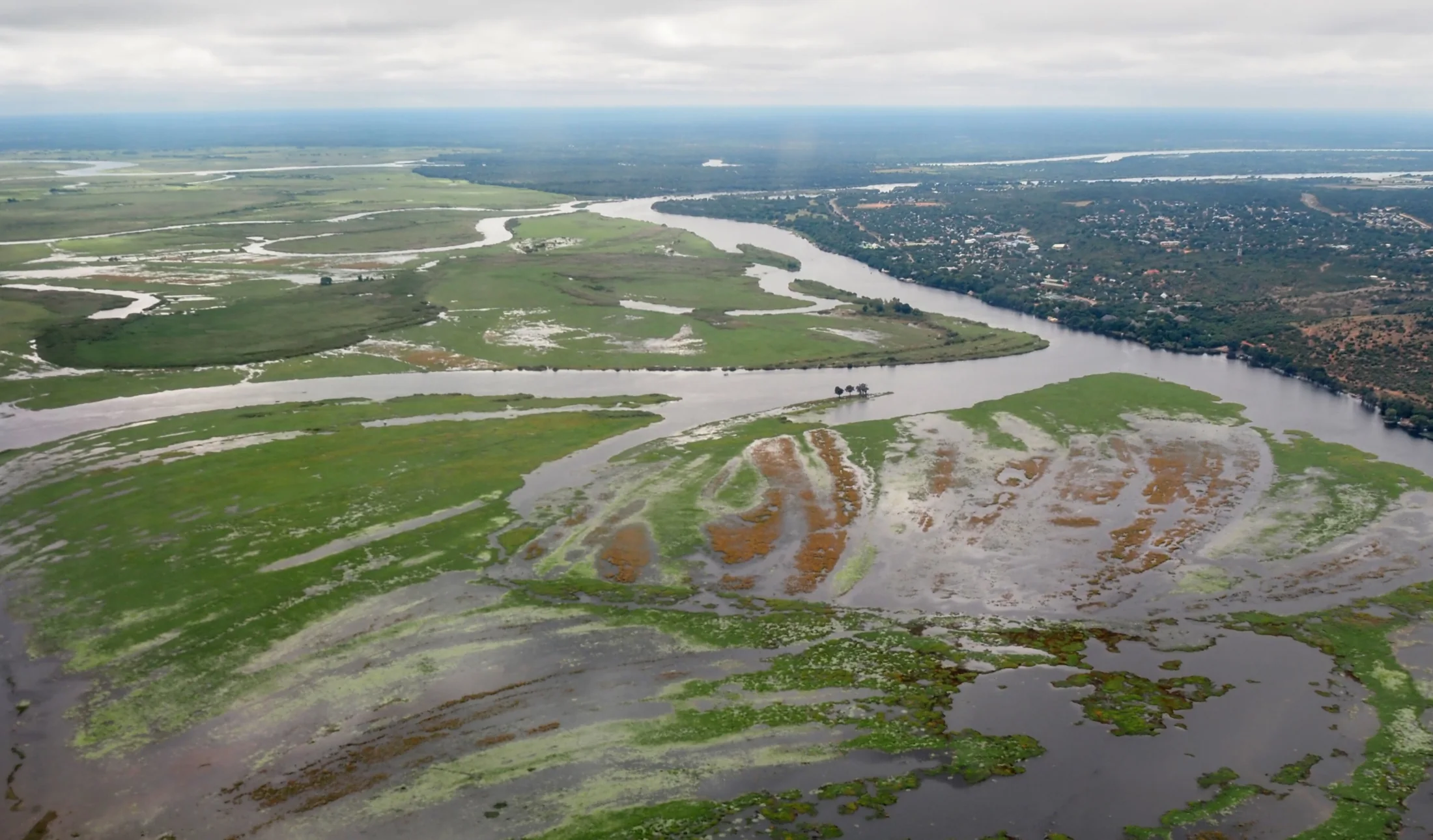 Aerial view of the Chobe River, riverside vegetation and buildings at Kasane