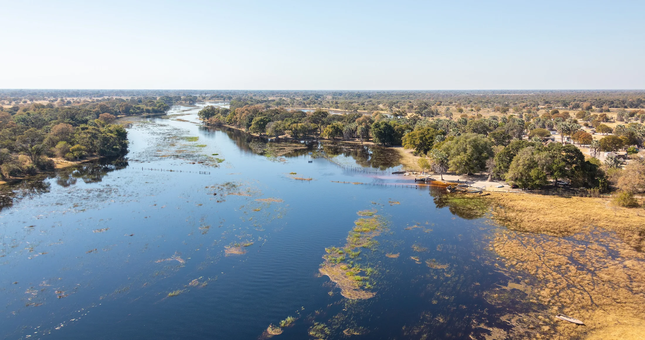 Waterside settlement and boats beside an Okavango Delta channel
